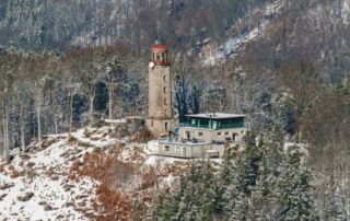 Kamenná rozhledna nad Prosečí s novou turistickou chatou se sněhovým popraškem - Jablonec nad Nisou