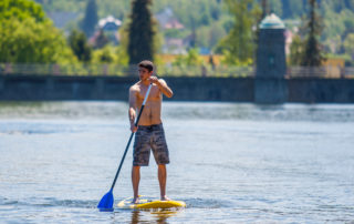 Mladý muž stojící na paddleboardu na přehradě v Jablonci nad Nisou