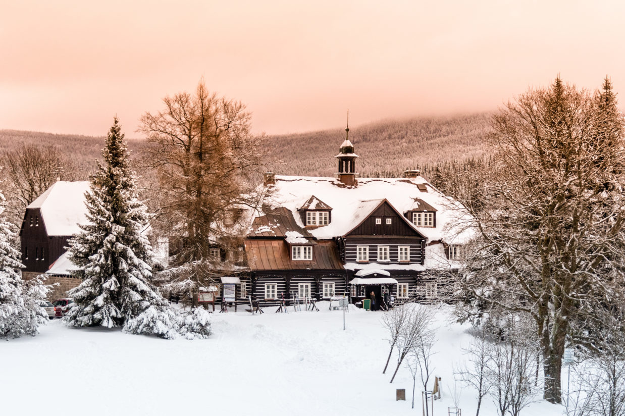 Zasněžená Šámalova chata na Nové Louce, dříve lovecký zámeček Clam-Gallasů, uprostřed lesů v Jizerských horách nabízí občertvení turistům i lyžařům.