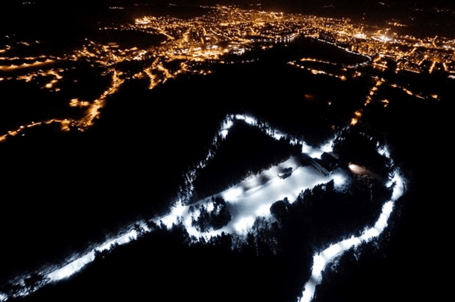 Letecký večerní snímek svítícího běžkařského areálu Kolečko – Jablonec nad Nisou Břízky v zimě