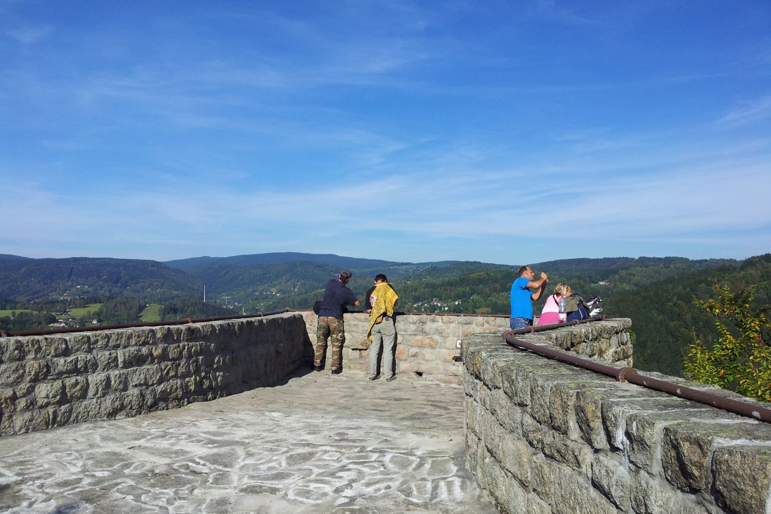 Turisté na kamenné terase skalní vyhlídky Terezínka nad městem Tanvald.