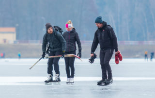 Tři bruslaři s hokejkami na přehradě v Jablonci nad Nisou
