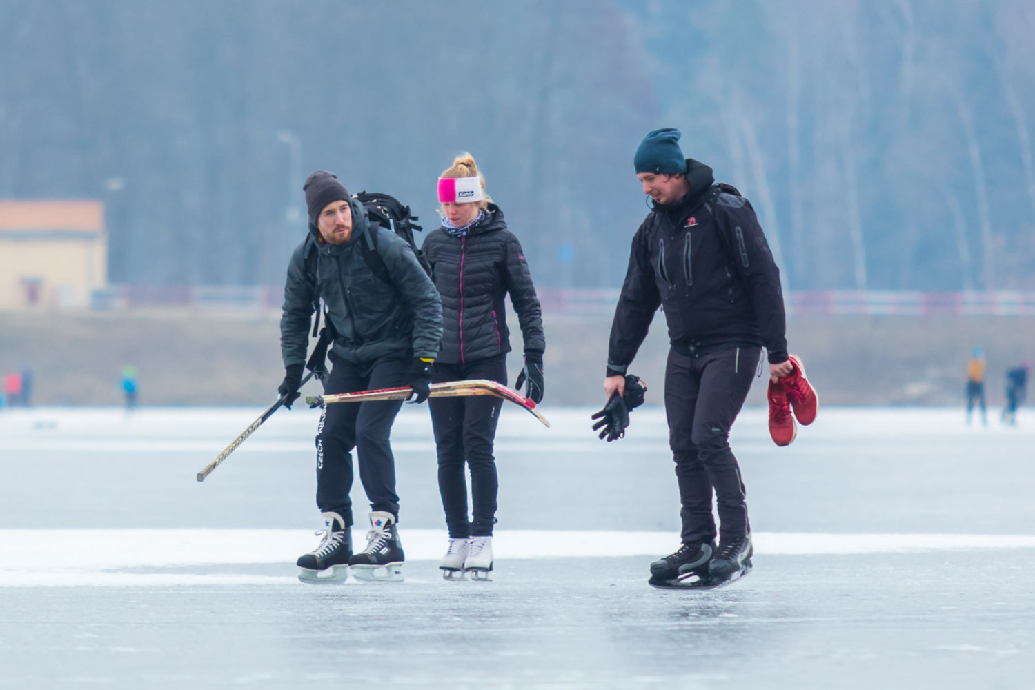 Tři bruslaři s hokejkami na přehradě v Jablonci nad Nisou