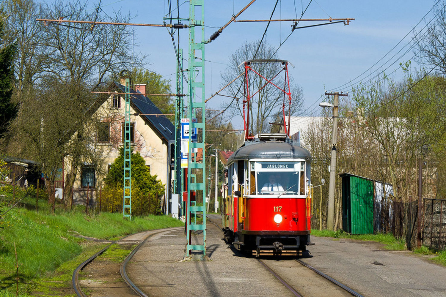 Historická tramvaj jedoucí po kolejích zástavbou mezi Libercem a Jabloncem